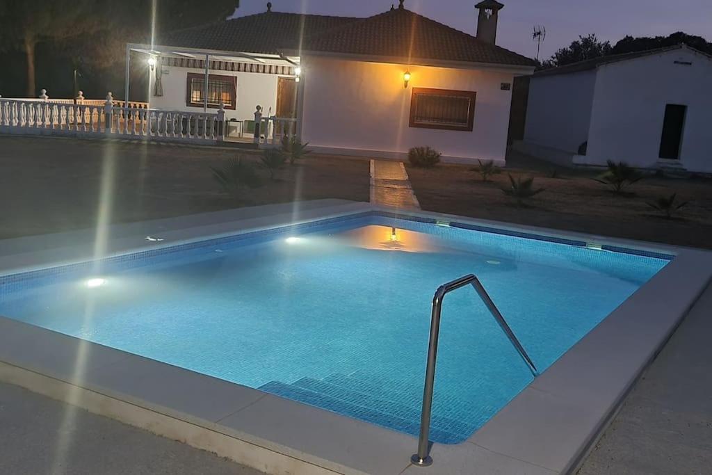 a swimming pool in front of a house at night at CHALET con ENCANTO en SIERRA CORDOBESA. WIFI in Cerro Muriano