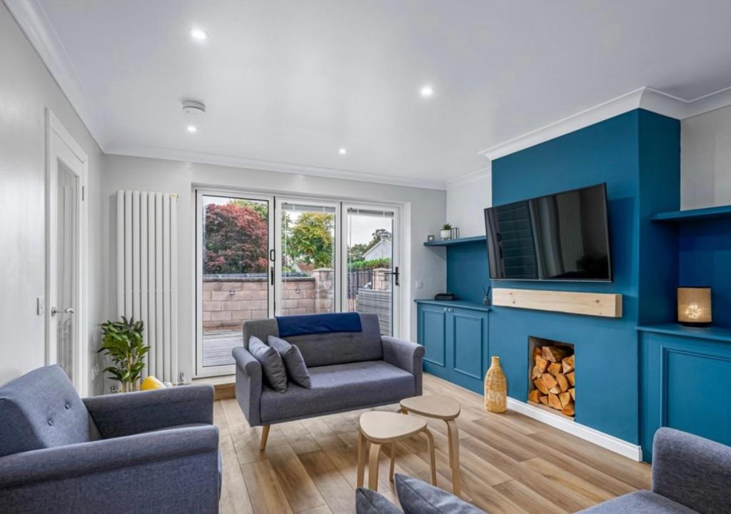 una sala de estar con una pared azul en The School House en Broughty Ferry