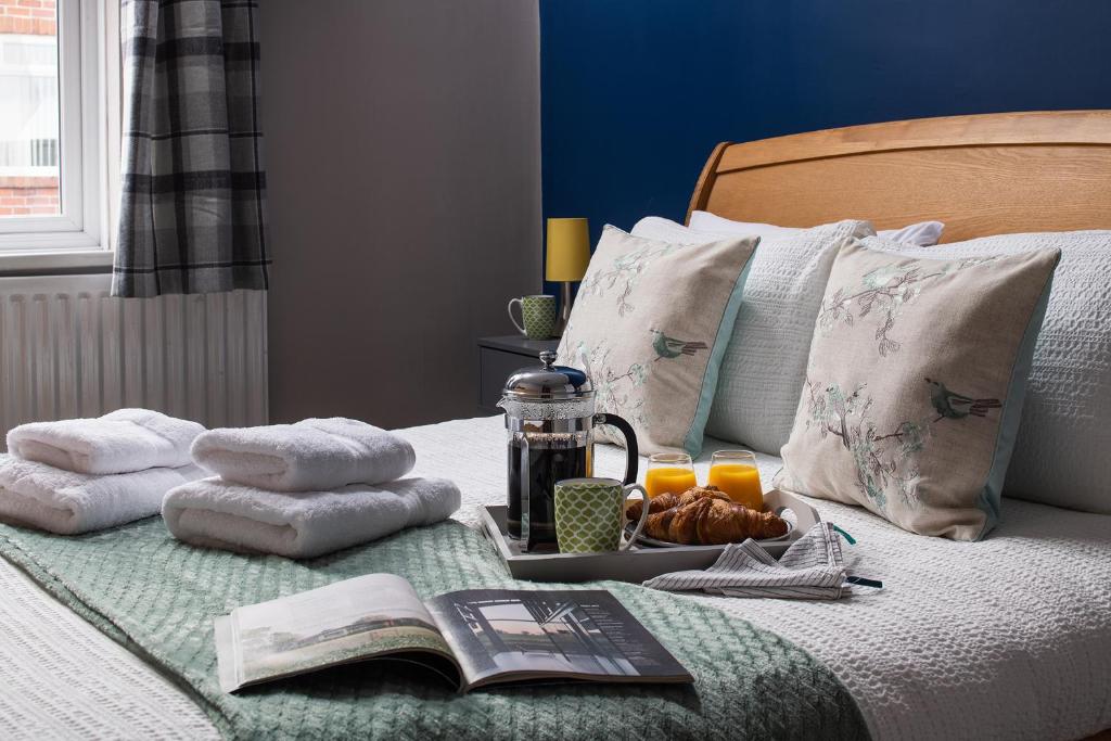 a tray of towels and a book on a bed at The Elderton, Newbiggin By The Sea, Northumberland in Newbiggin-by-the-Sea