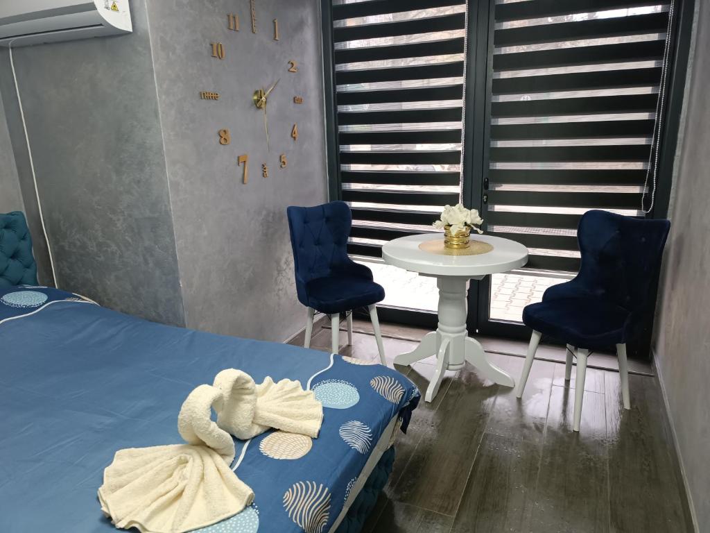 - une chambre avec un lit, deux chaises et une table dans l'établissement Apartment 1 Novi Sad, à Novi Sad