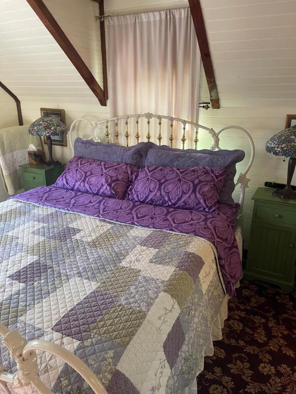a bed with a purple comforter in a bedroom at Downtown B&B with Jacuzzi in Glenwood Springs