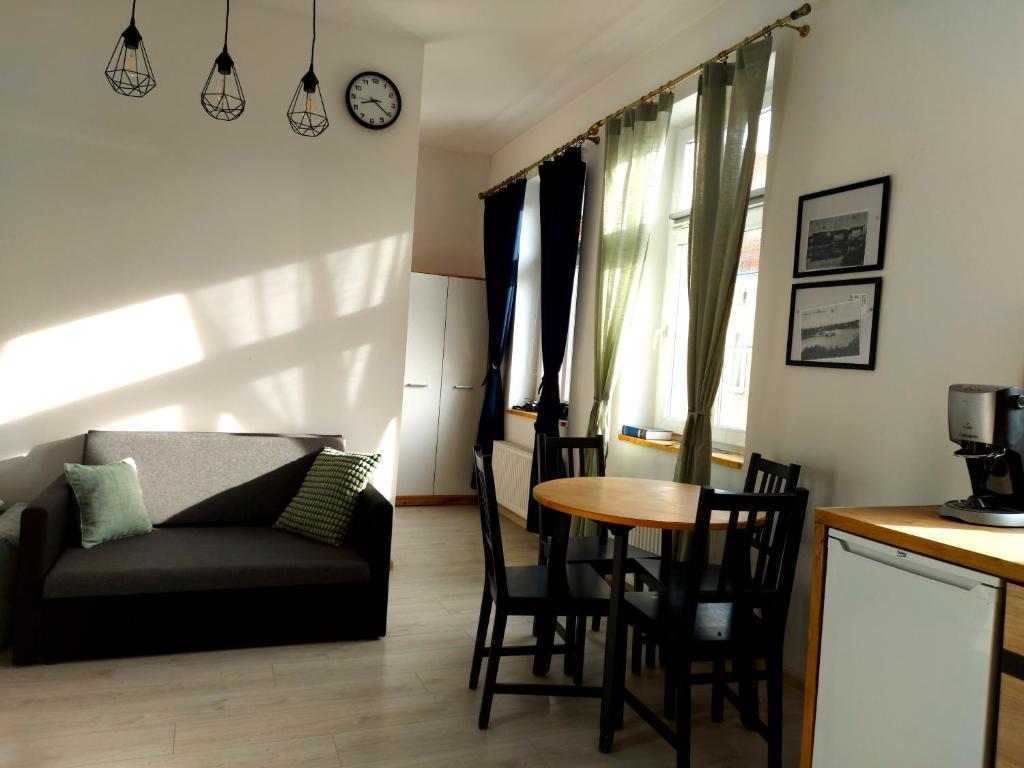 een woonkamer met een bank en een tafel bij Apartament Kętrzyński in Kętrzyn