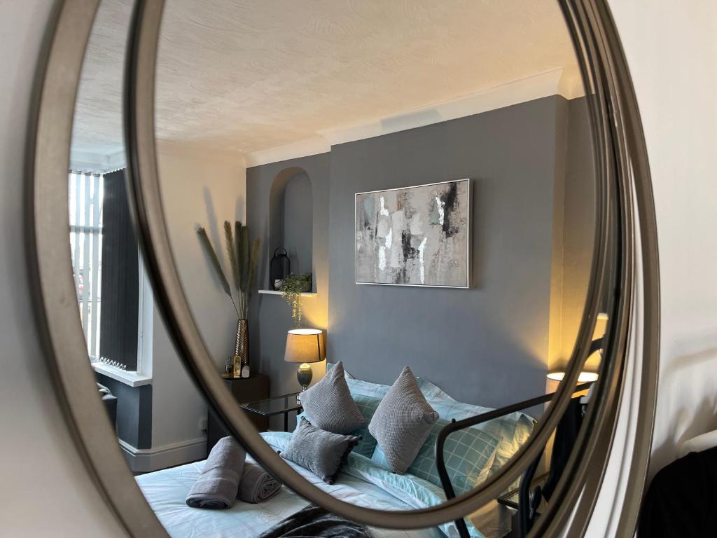 ein Spiegel, der ein Schlafzimmer mit einem Bett und Kissen reflektiert in der Unterkunft Casa Lobo's Beautiful Suites Apartment 1 free offroad parking in Fallings Park