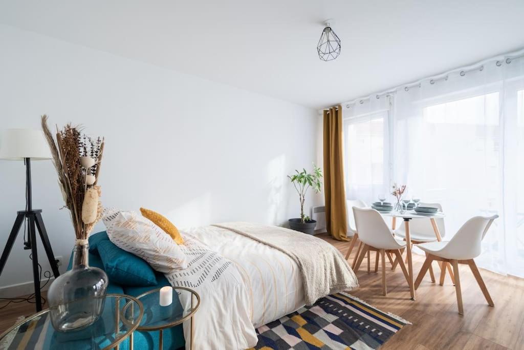 Schlafzimmer mit einem Bett, einem Tisch und Stühlen in der Unterkunft Le Nid Douillet T2, Wifi, Parking privé gratuit in Lille