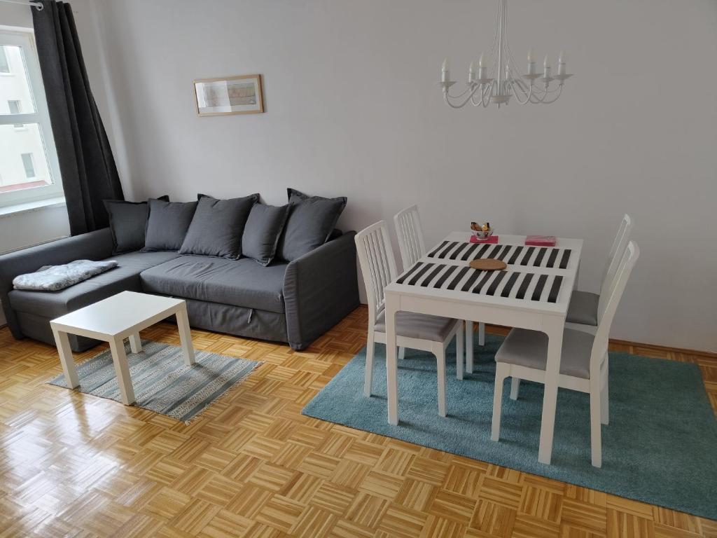 salon z kanapą, stołem i krzesłami w obiekcie Apartament Zieleniec w Toruniu