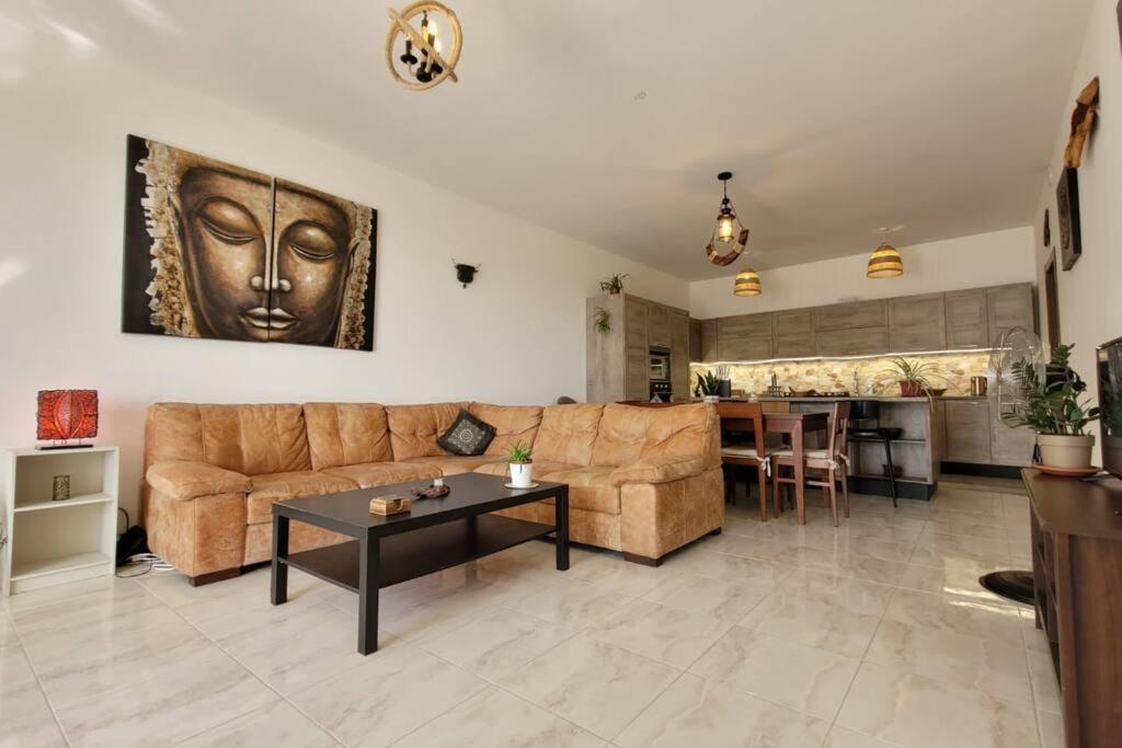 ein Wohnzimmer mit einem Sofa und einem Tisch in der Unterkunft Luxury en-suite Double. Beach-house with Sea Views in Mellieħa