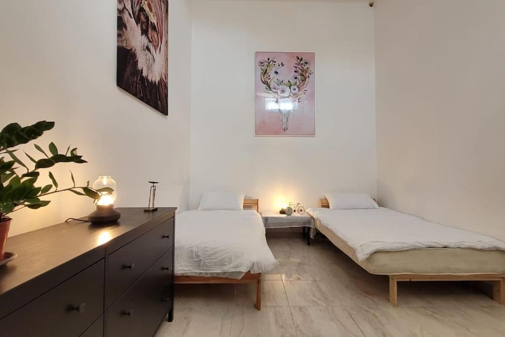 a bedroom with two beds and a desk with a plant at Luxury en-suite Double. Beach-house with Sea Views in Mellieħa