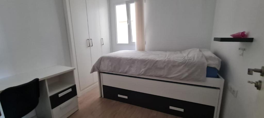 ガンディアにあるDormitorios piso Gandiaの小さなベッドルーム(ベッド1台、デスク付)
