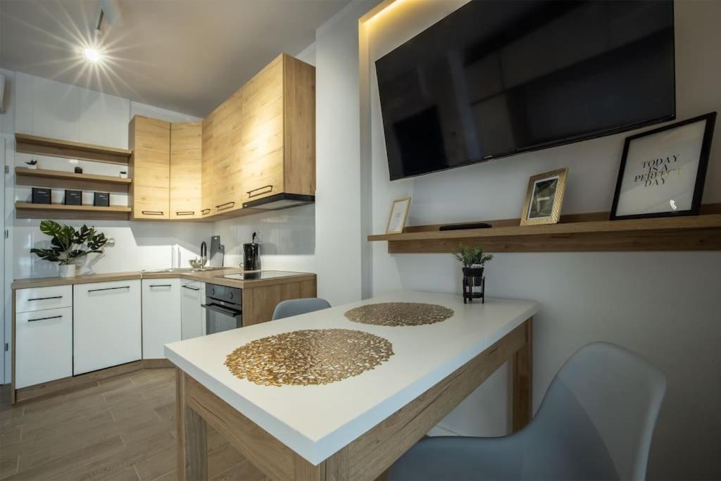 a kitchen with a white counter top and a table at WiguryTower Apartaments 68' in Łódź