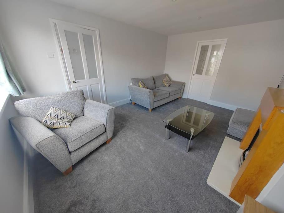 - un salon avec deux chaises et une table dans l'établissement Cosy Brighouse 3 bed house-Great for contractors, à Brighouse