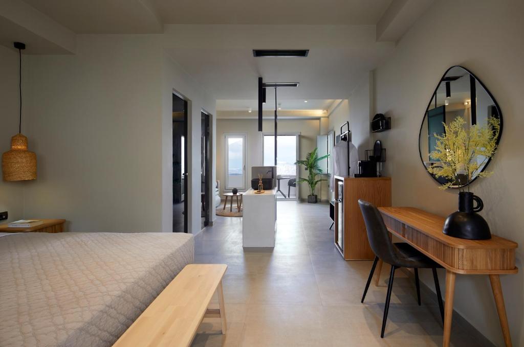 um quarto com uma cama, uma mesa e um espelho em Mayu Suites em Pirgos