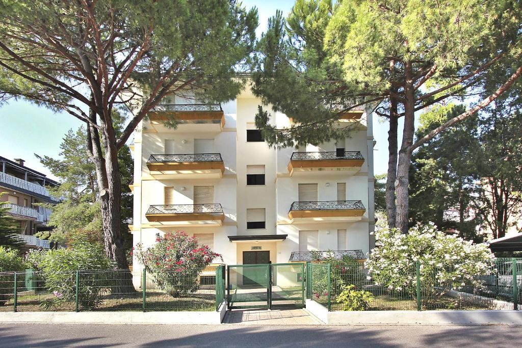 リニャーノ・サッビアドーロにあるResidenza Ibsenの白い高い建物の前に木々