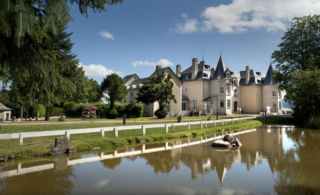 un castillo con un río delante de él en Le Château D'orfeuillette en La Garde