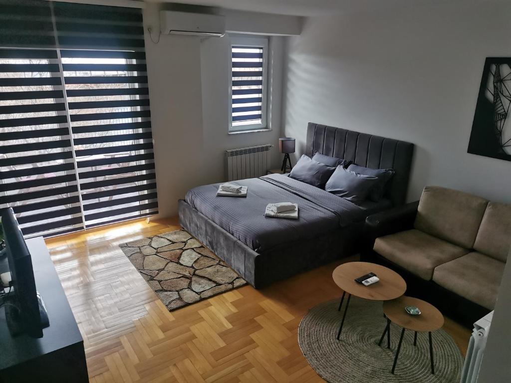 um quarto com uma cama, um sofá e uma mesa em skopje modern studio em Skopje