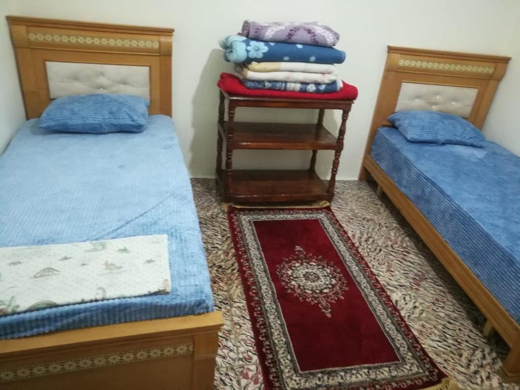 - une chambre avec 2 lits et une table de chevet dans l'établissement Dar Abdlouahed, à Chefchaouen