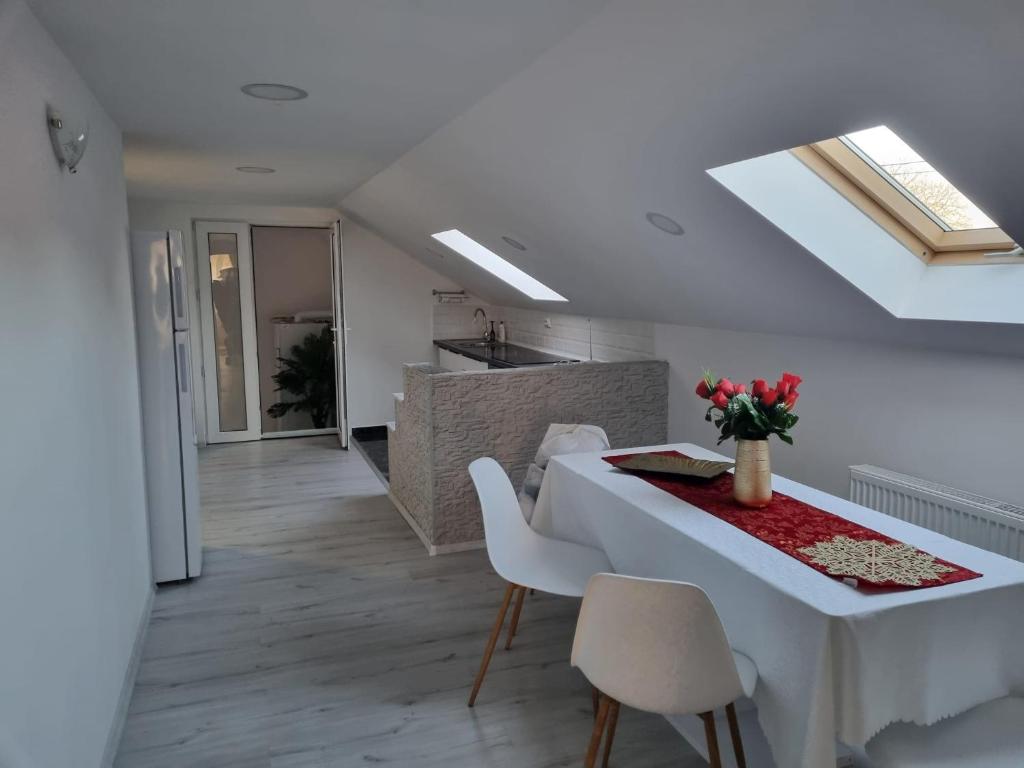 a kitchen and dining room with a white table and chairs at Izabella Guest House in Săcele