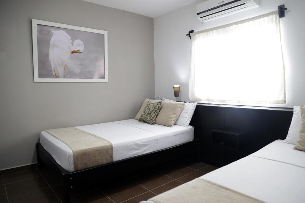 a bedroom with two beds and a window at Hotel-Restaurante Ancora in Puerto López