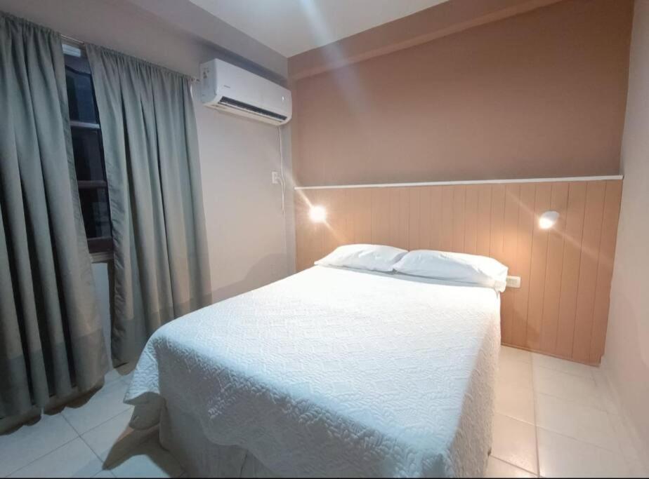 una camera da letto con un letto bianco e una finestra di Apart Checatu I a Corrientes