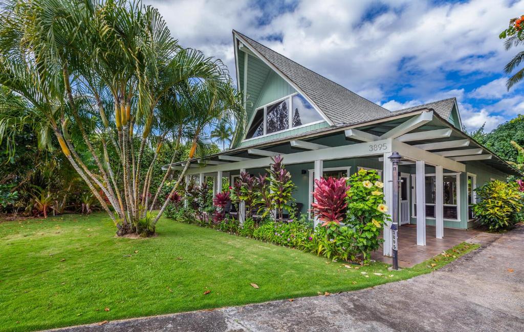 a house with a palm tree in front of it at Ailana Hale in Princeville