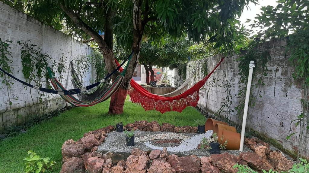 a hammock hanging from a tree in a garden at Vila dos Bangalôs in Barreirinhas