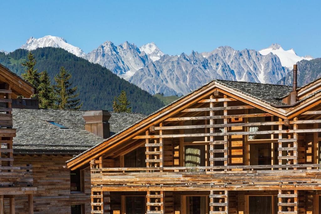 una casa de madera en construcción con montañas en el fondo en W Verbier, en Verbier