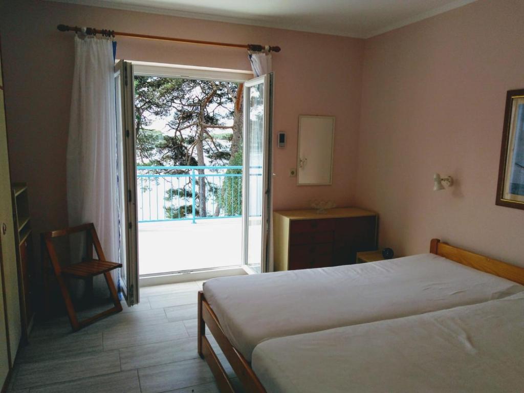 a bedroom with a bed and a sliding glass door at Casa Liliana By the Sea in Mali Lošinj
