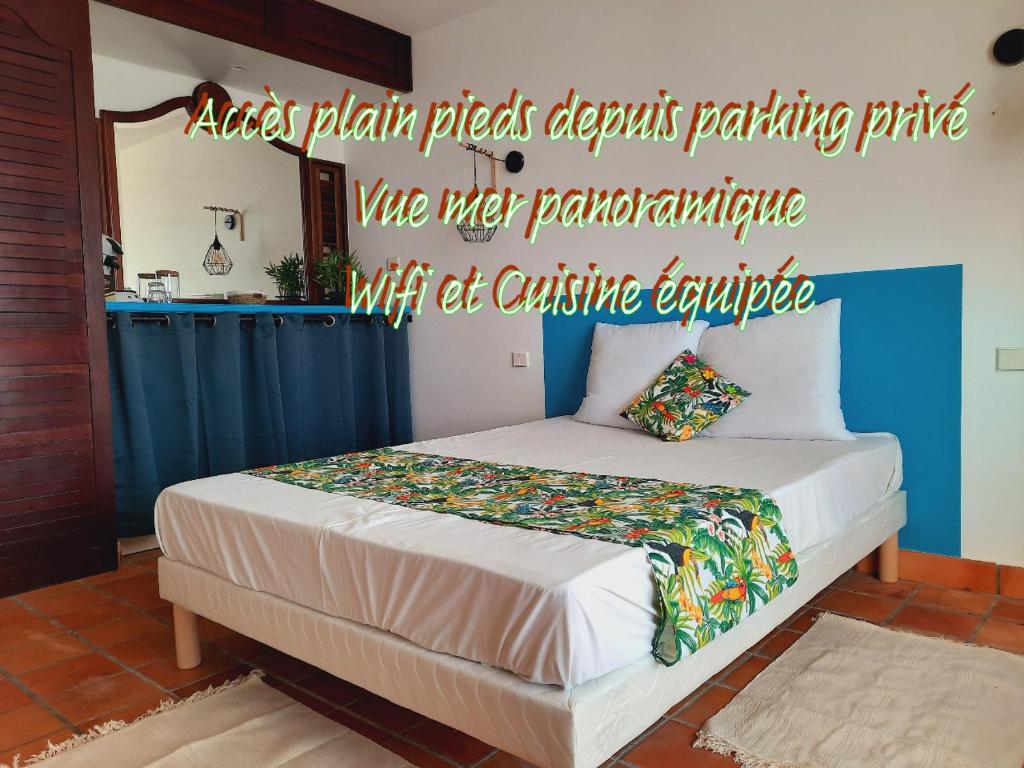 ein Schlafzimmer mit einem Bett mit einem Schild an der Wand in der Unterkunft Martinique La Trinité KAZAKASSY Studio plain-pied, fonctionnel et vue mer in La Trinité