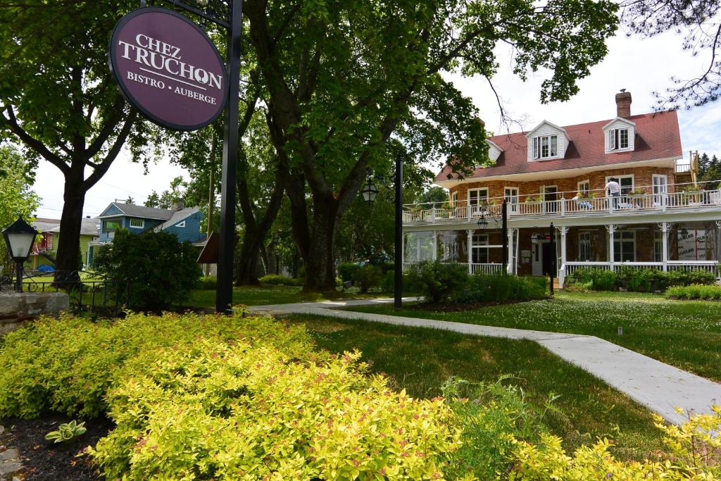 un panneau devant une grande maison dans l'établissement Chez Truchon Bistro-Auberge, à La Malbaie