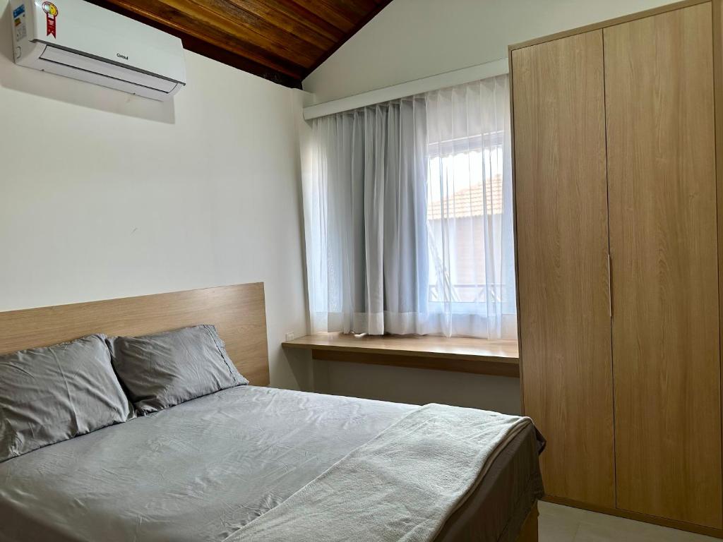 a small bedroom with a bed and a window at Casa Praia dos Carneiros in Tamandaré