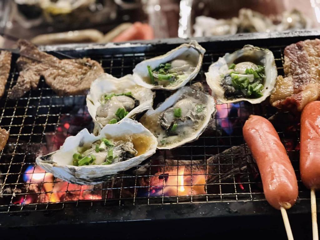 a group of oysters on a grill with a carrot at Boong Home - Pác Bó, Cao Bằng 
