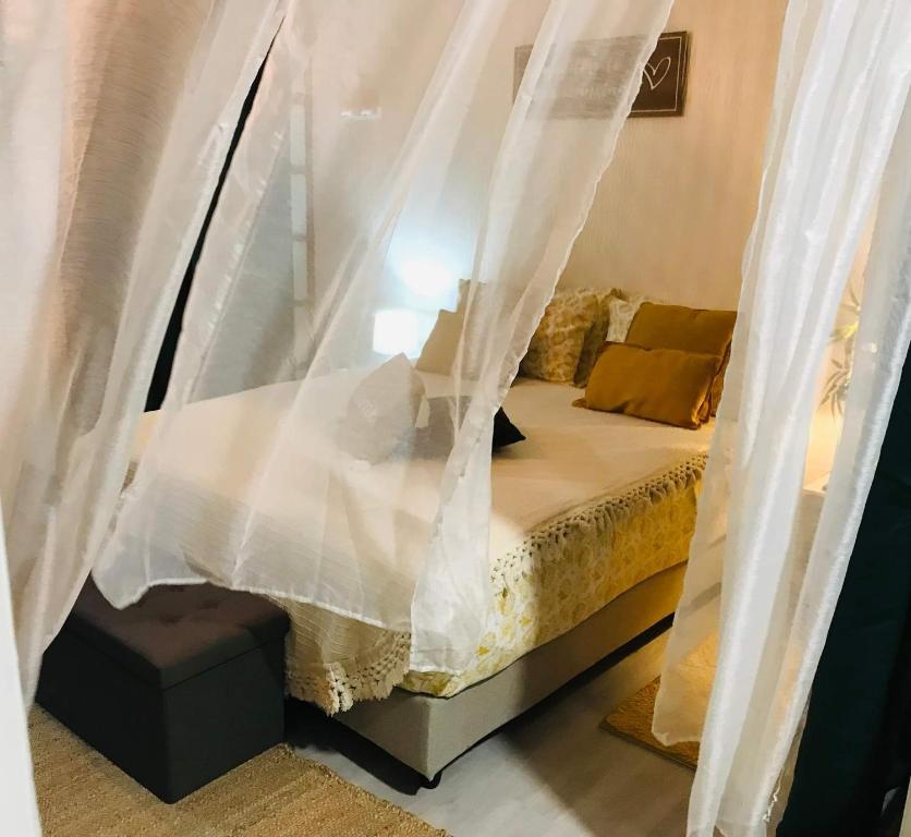 1 dormitorio con 1 cama con cortinas blancas en Mave Mai Studio Papeete en Papeete
