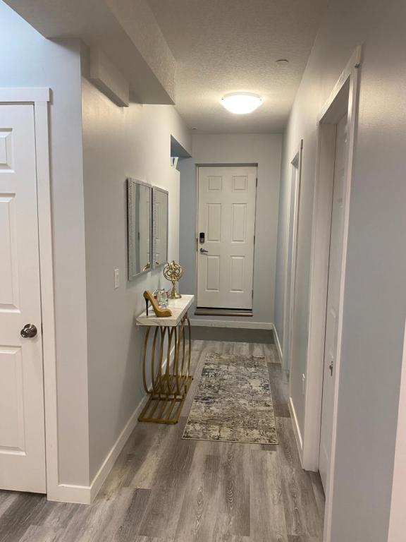 a hallway with a white door and a table at A very nice Basement ensuite. in Calgary