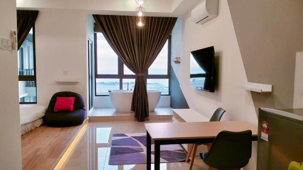 a living room with a table and chairs and a tub at NEW Stylish Seaview Bali Residences studio near Jonker 4 pax in Melaka