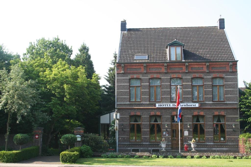 een groot bakstenen gebouw met een bord erop bij Hotel Beukenhorst in Wittem