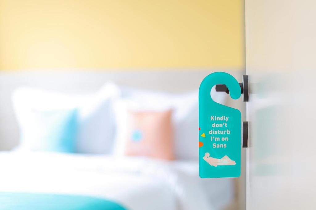 Postel nebo postele na pokoji v ubytování Sans Hotel Clover Ace Surabaya by RedDoorz