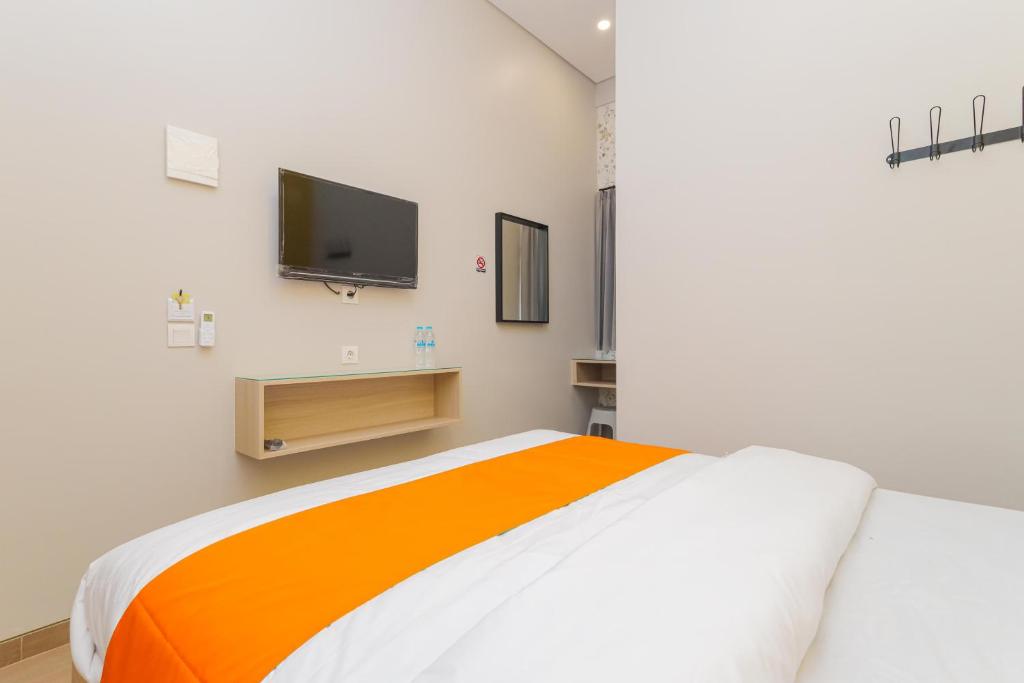 Postel nebo postele na pokoji v ubytování Sans Hotel Clover Ace Surabaya by RedDoorz