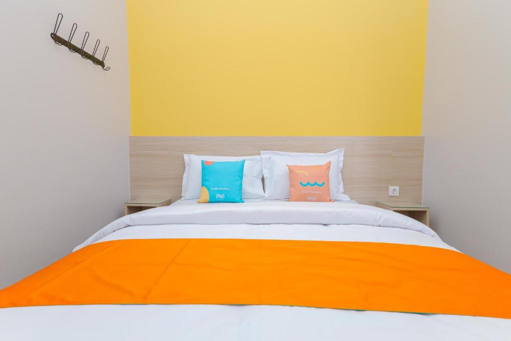 Postel nebo postele na pokoji v ubytování Sans Hotel Clover Ace Surabaya by RedDoorz