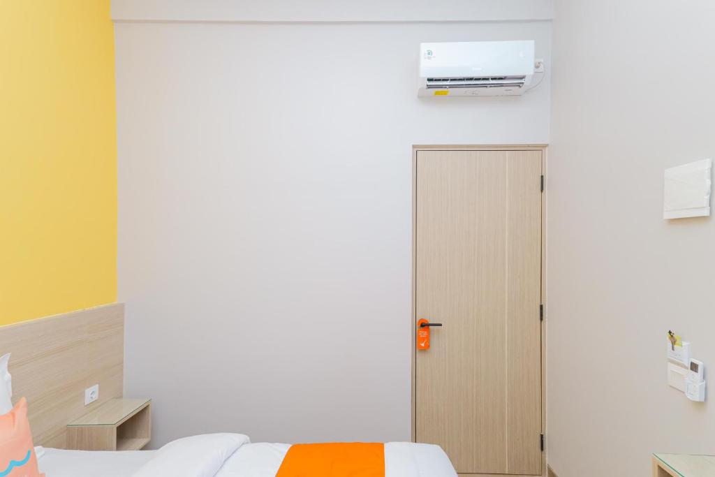 Postel nebo postele na pokoji v ubytování Sans Hotel Clover Ace Surabaya by RedDoorz