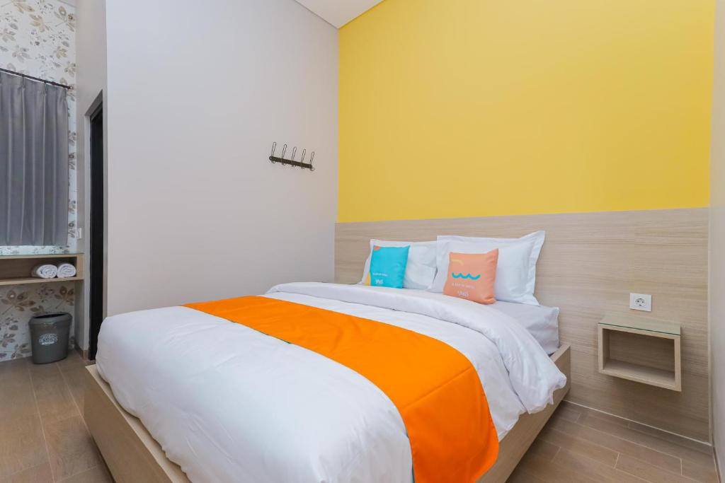 Postel nebo postele na pokoji v ubytování Sans Hotel Clover Ace Surabaya by RedDoorz