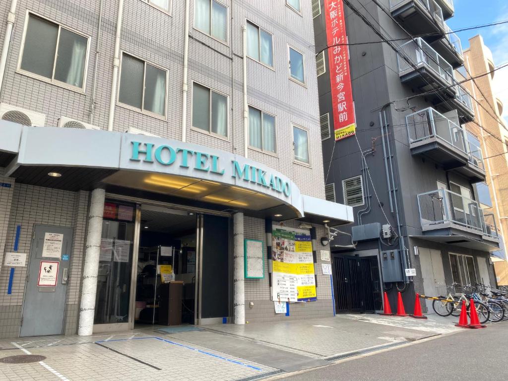 een hotel met een bord aan de voorzijde van een gebouw bij Hotel Mikado in Osaka