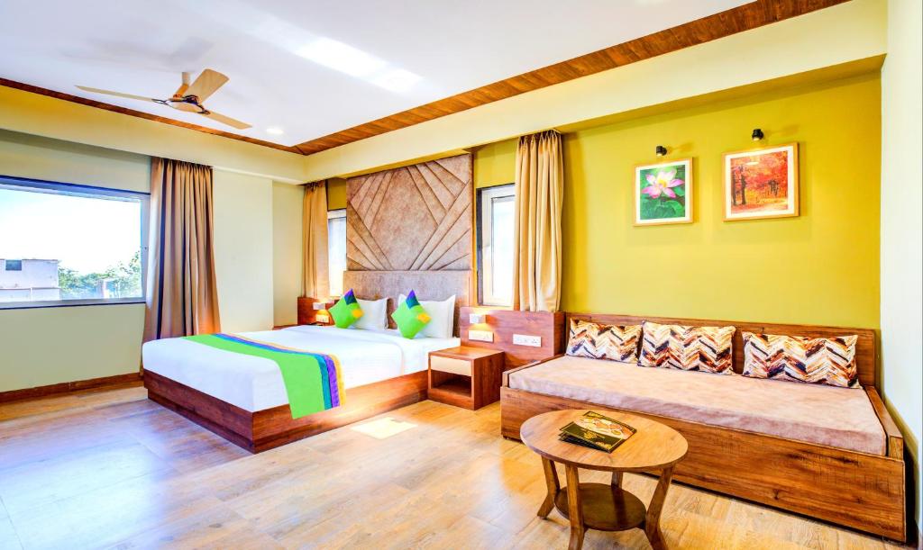 a bedroom with a bed and a couch at Treebo Trend Opulence Inn in Udaipur
