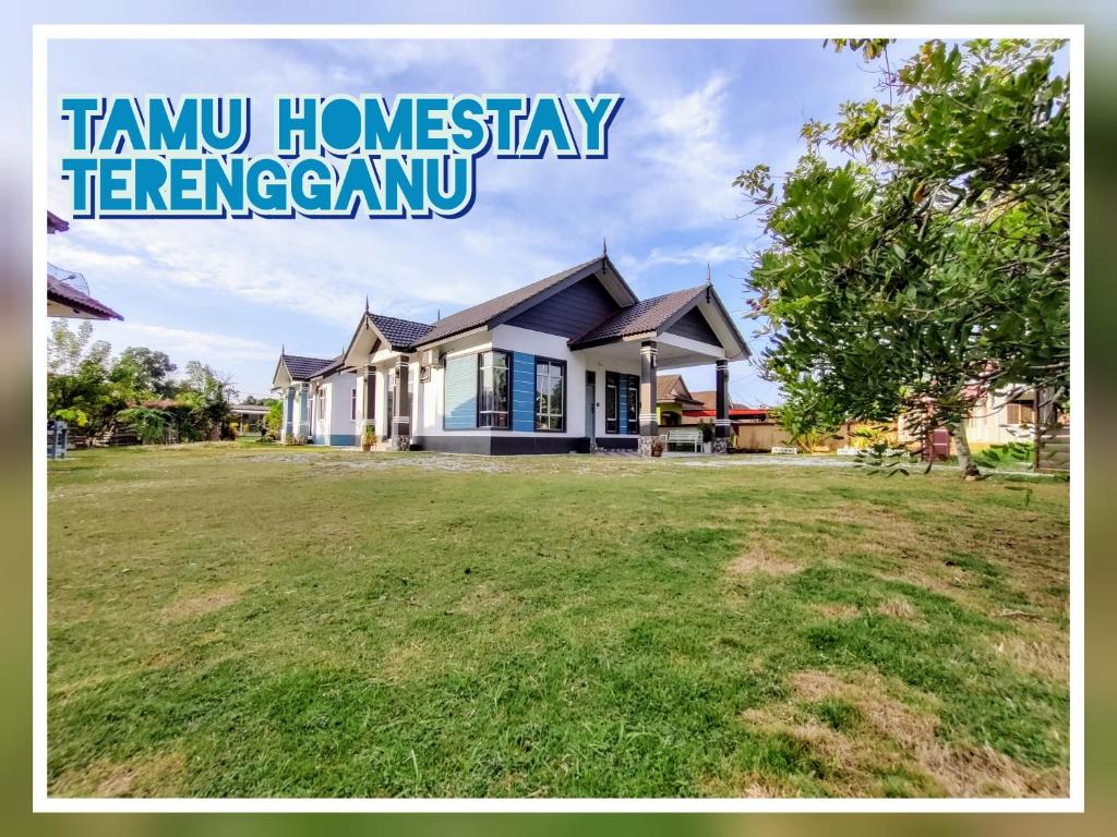 a house with a large yard in front of it at Tamu Homestay Terengganu in Kuala Terengganu