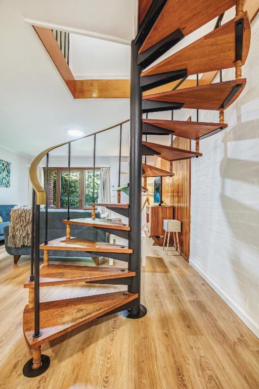 a spiral staircase in a house with a living room at Cedar Cottage Unit 5 in Bright