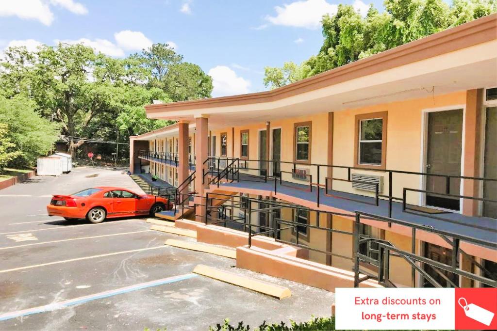 ein Gebäude mit einem Auto auf einem Parkplatz in der Unterkunft OYO Hotel Tallahassee Downtown in Tallahassee