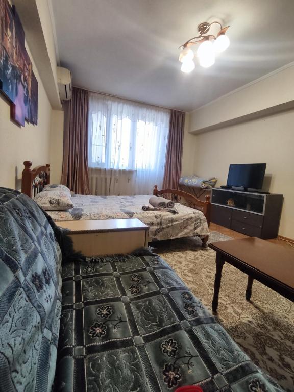um quarto de hotel com duas camas e uma televisão em X,ata 2 em Almaty