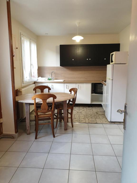 a kitchen with a table and chairs and a refrigerator at Le Veymont in Saint-Martin-en-Vercors