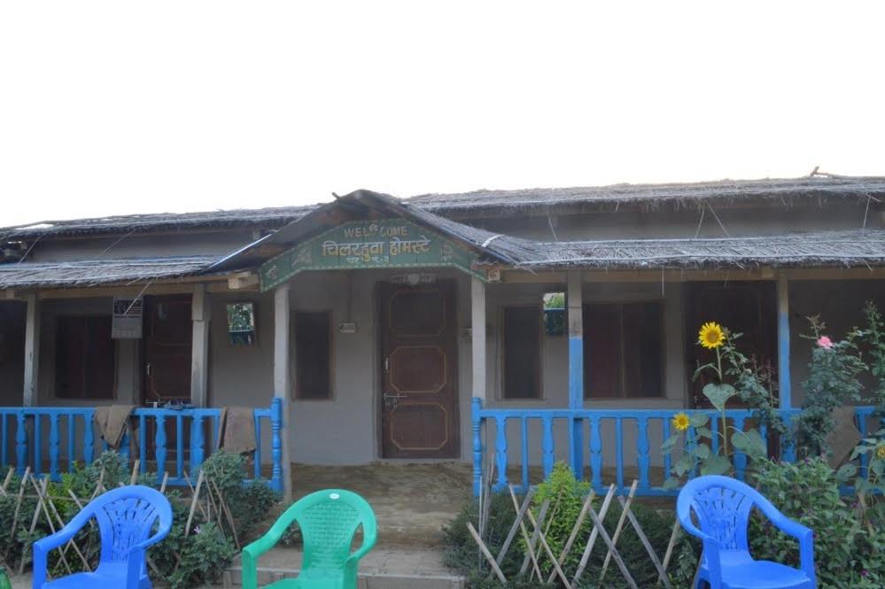 dom z niebieskimi krzesłami przed nim w obiekcie Bhada Community Homestay 