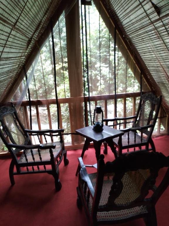 Zimmer mit 2 Stühlen und einem Tisch vor einem Fenster in der Unterkunft Riverston Du Eco Cottage in Rattota