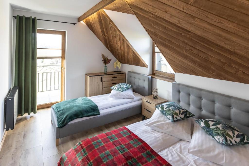 a bedroom with two beds and a window at Dychnijzese in Czarna Góra