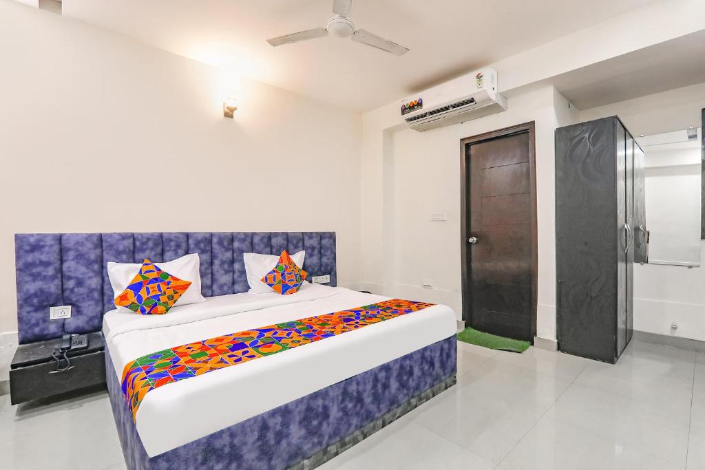 a bedroom with a large bed with colorful pillows at FabHotel Silver Stone Inn in Lucknow